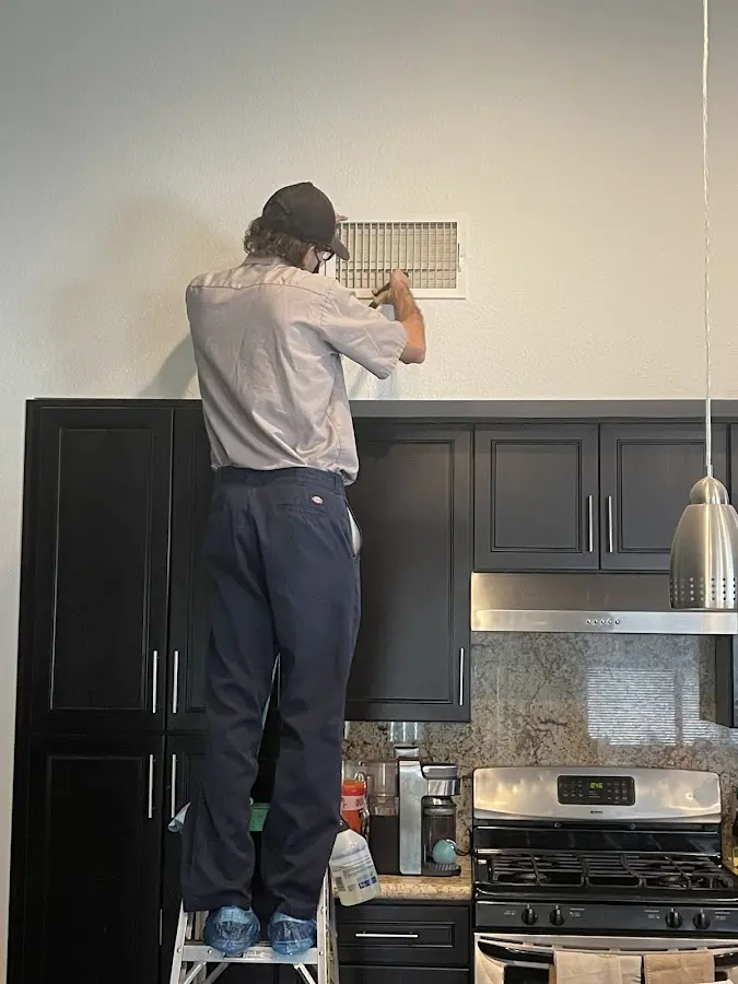 Technician inspecting an air vent during HVAC service in Steamboat Springs